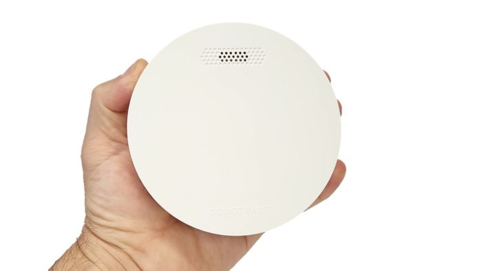 ZEN Photoelectric Smoke Alarm held in the hand showing slimline profile